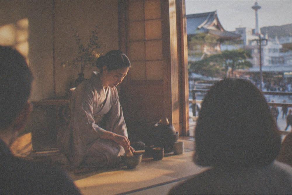 A tea master whisking matcha in a wooden Kyoto tea room before a small group