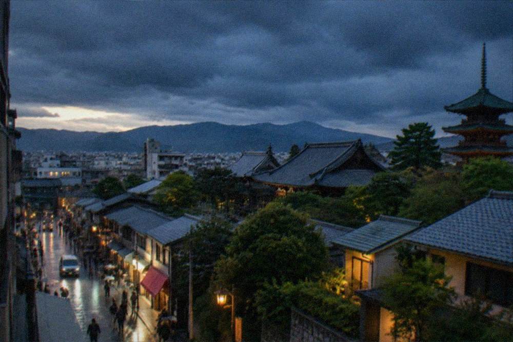 Dark storm clouds gathering over the Kyoto skyline with temple roofs below