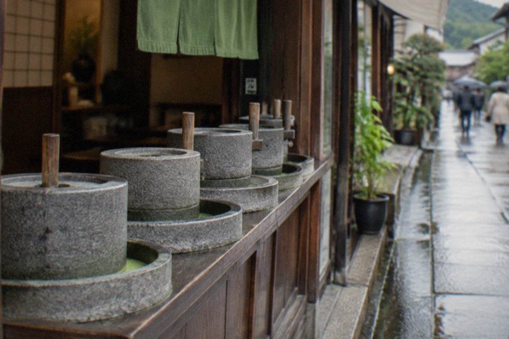 Stone tea mills arranged in a row inside a traditional tea shop