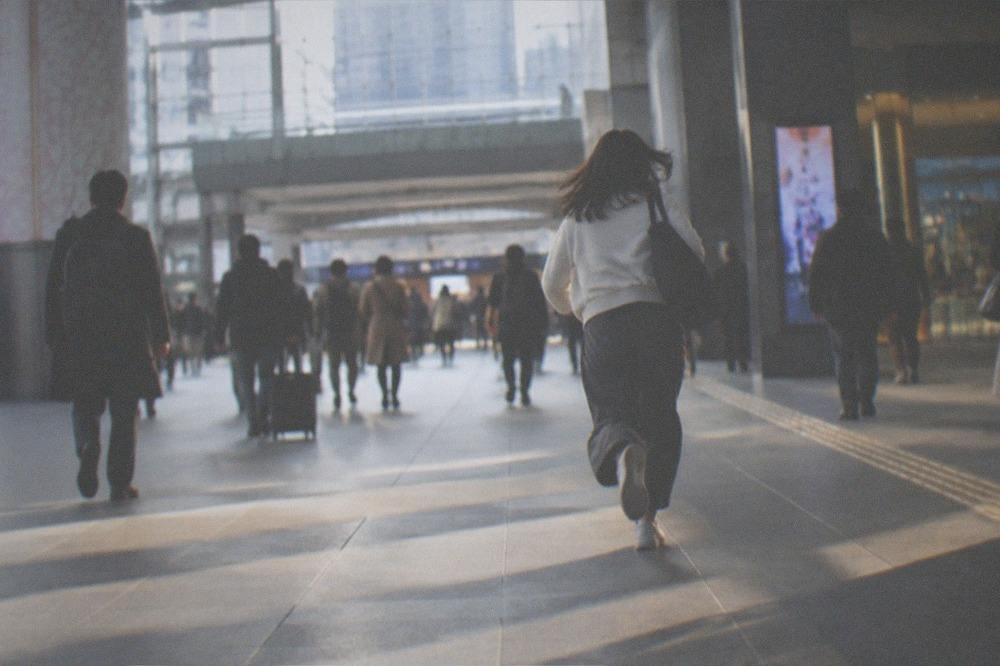 A busy Kyoto Station concourse with travellers and departure boards