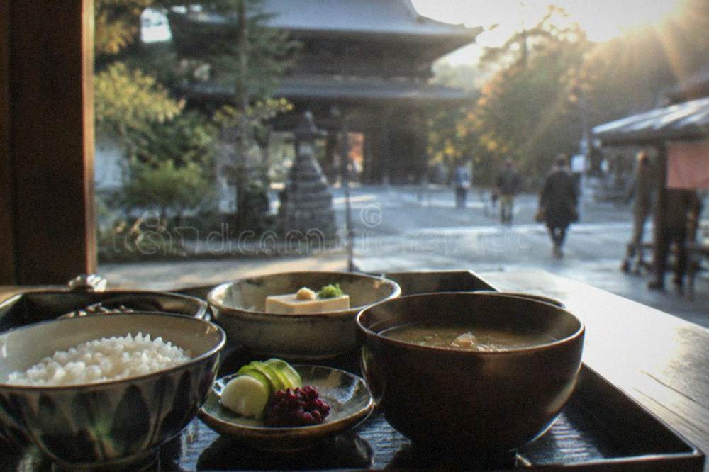 A zen temple meal of rice, pickled vegetables, tofu and miso soup arranged on a black lacquer tray