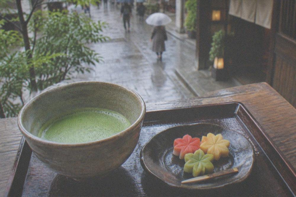 Traditional wagashi sweets shaped like seasonal leaves served with a bowl of matcha tea