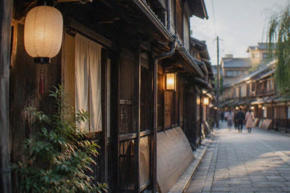 Evening lights along a narrow lane of traditional wooden machiya townhouses in central Kyoto