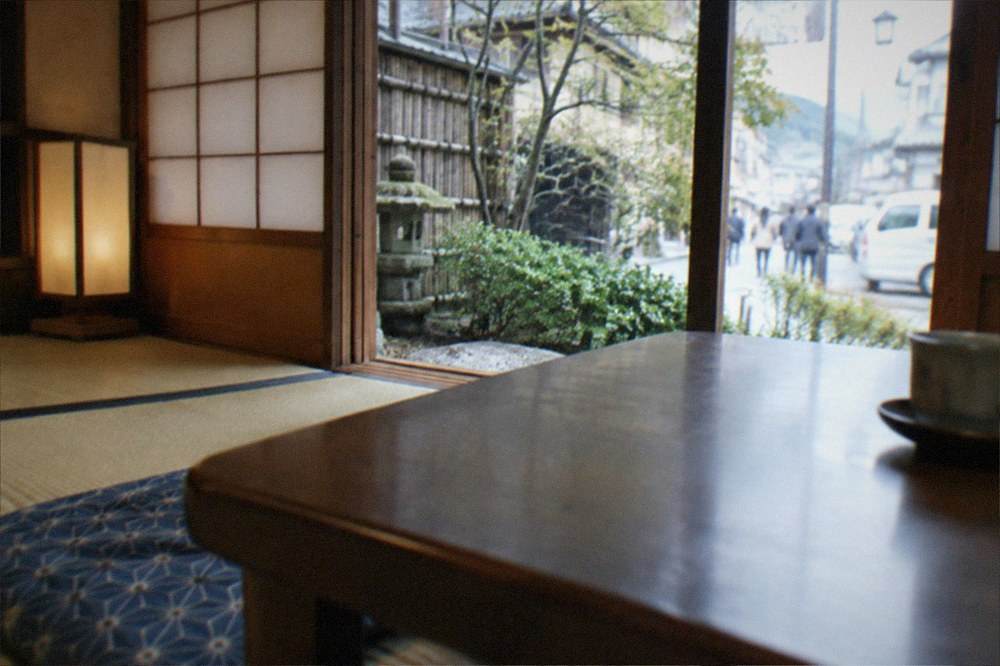 A traditional machiya townhouse interior with tatami flooring, paper screens and a low table