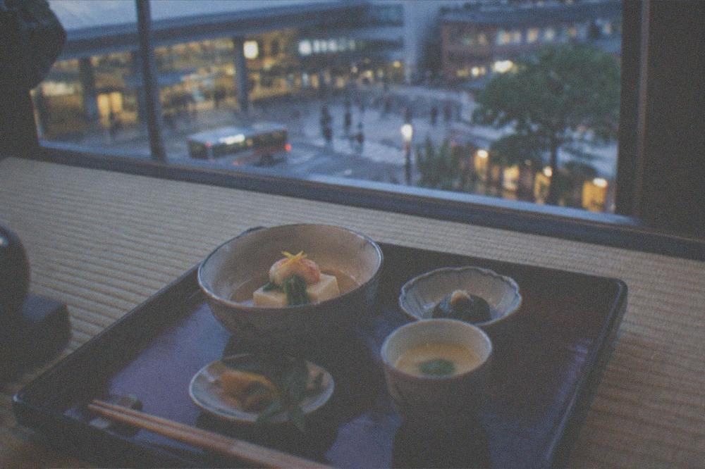 A lacquered tray with a small kaiseki course set on a tatami dining room floor