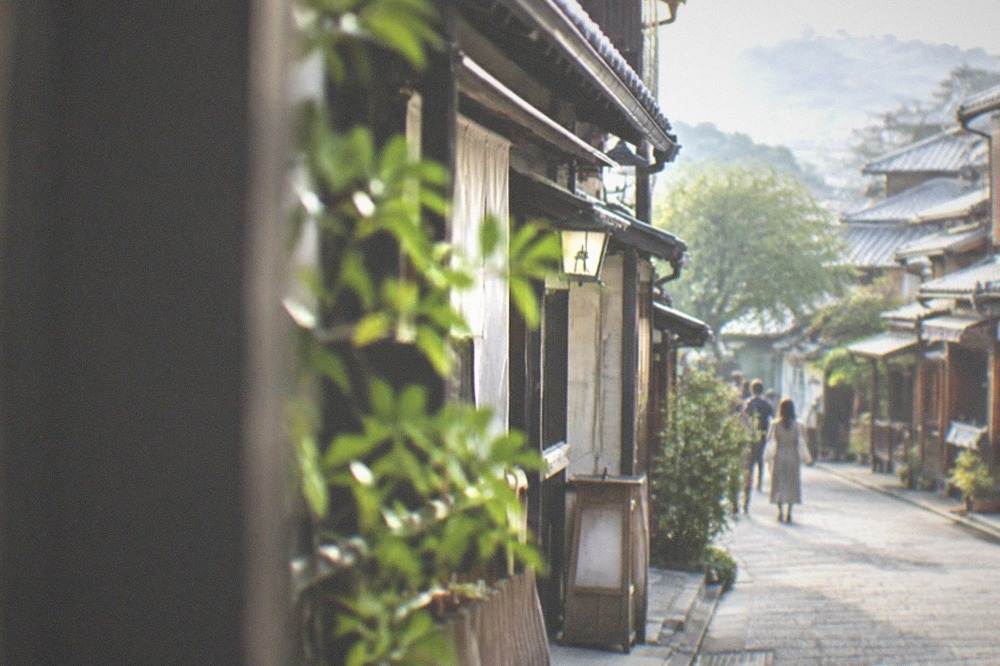 The preserved wooden machiya shopfronts of a Higashiyama lane in the early morning