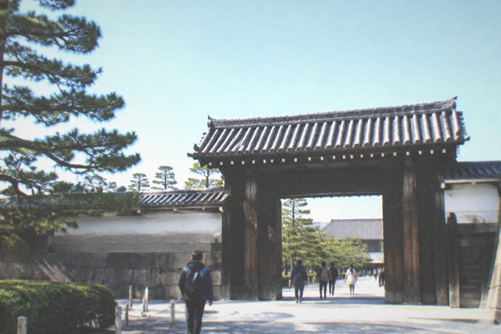 Stone gate and grounds of Nijo-jo Castle under a clear sky