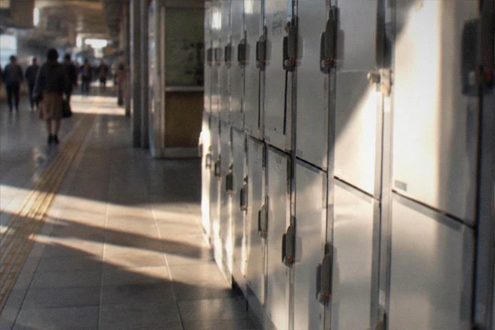 Rows of coin lockers along a wall in a Japanese railway station corridor