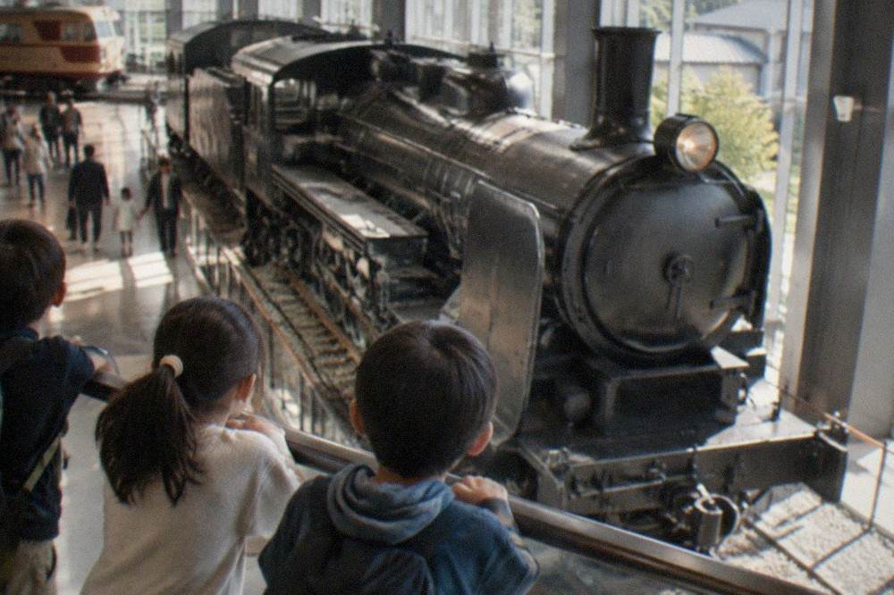Children watching a steam locomotive on display inside the Kyoto Railway Museum