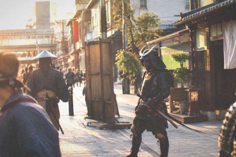Actors in samurai costume performing on an Edo-period film set street