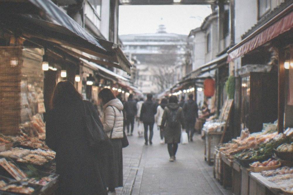 A narrow covered market lane with food stalls on both sides and shoppers browsing in the afternoon