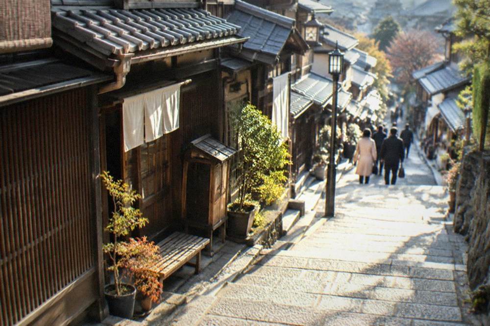 A stone-paved slope lane with traditional wooden machiya shopfronts in Kyoto's Higashiyama district
